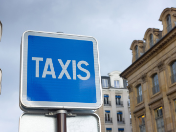 Taxi, napis na niebieskim szyldzie. Postój taksówek w Paryżu.