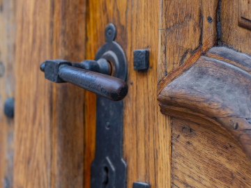 Drewniane drzwi i stalowa klamka