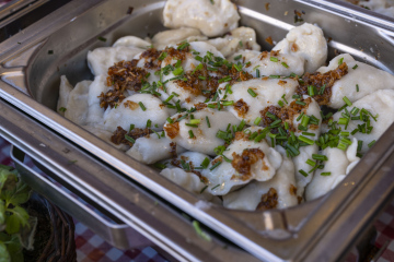 Pierogi posypane szczypiorkiem i smażoną cebulą