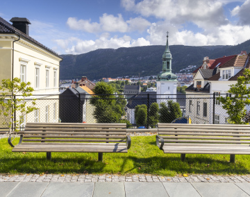 Dwie ławki obok chodnika i widok na kościół Nykirken w Bergen, Norwegia