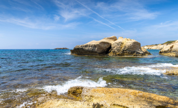 Skały wystające z morza przy brzegu - zdjęcie stockowe