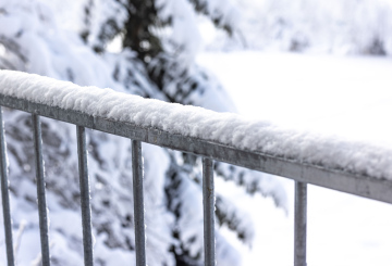 Zima, świeży śnieg na barierce balkonowej