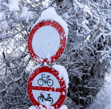 Opady śniegu. Sroga zima i zasypane znaki drogowe.