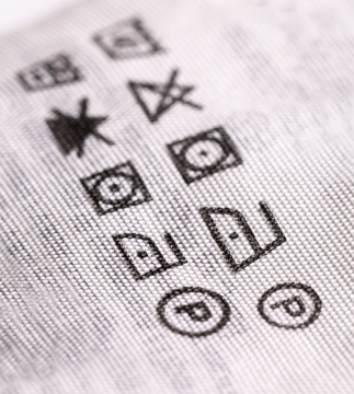 Etykieta na ubraniu z oznaczeniem sposobu prania i prasowania
