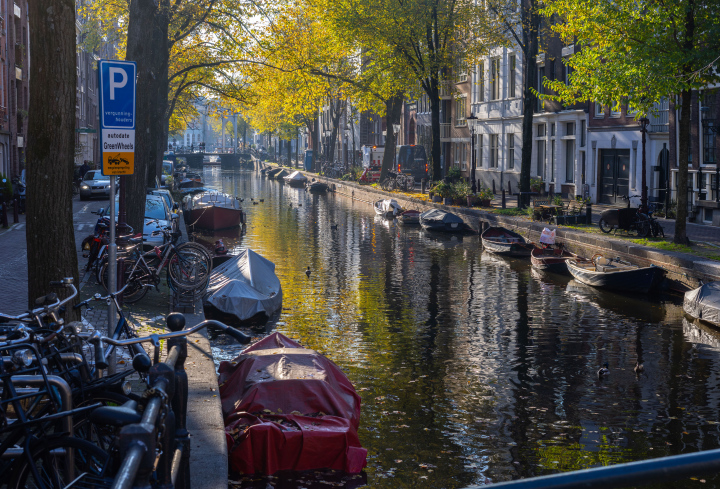 Kanał w Amsterdamie i łodzie przykryte plandekami